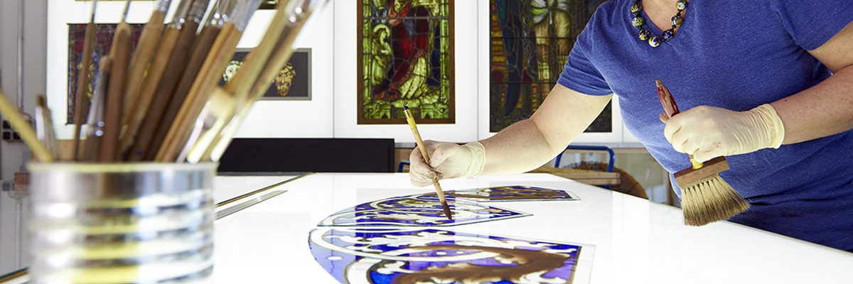 Handwerker der Mayer'schen Hofkunstanstalt GmbH bei der Erstellung von Glasmalerei und Mosaik in der Werkstatt in München.